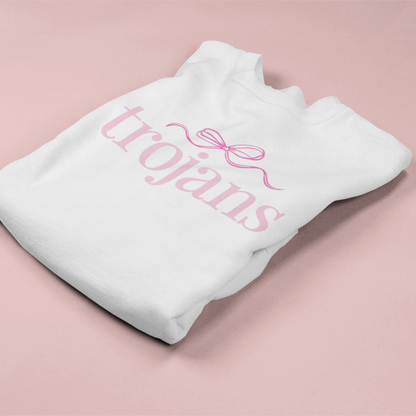 White sweatshirt with 'trojans' text and pink bow on a pink background